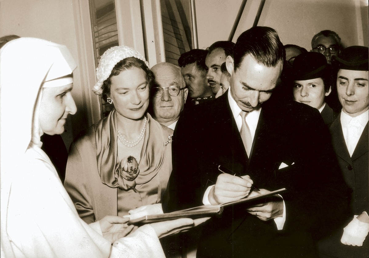 490_008_432592_Das großherzogliche Paar trägt sich in ein goldenes Buch ein.