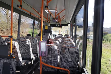 Im Bus geht’s durch die Landschaft. Dank der Vielfalt luxemburgischer Busunternehmer erlebt man alle möglichen Designs, hier schwarz-weiß-orange.