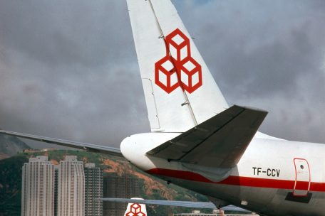 Eine CL-44 in Hongkong, im Vordergrund das Heck einer DC-8