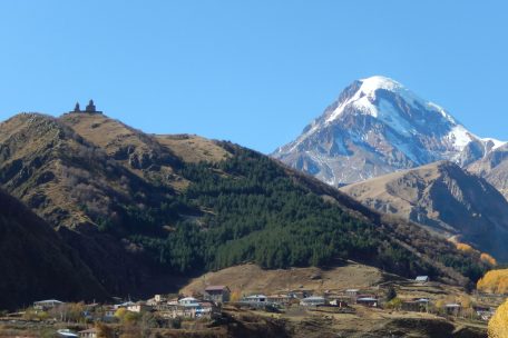 Die Gergeti Trinity Church aus dem 14. Jahrhundert vor dem Hintergrund des fünfthöchsten Gipfels Europas, dem Berg Kasbek