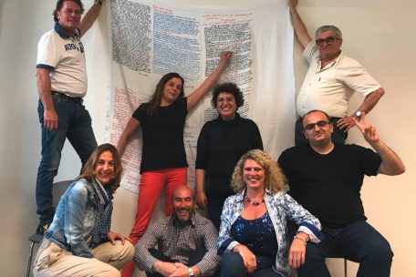 Claudio Cicotti (assis au centre) et les participants à un atelier d’écriture, autour d’un „drap“ autobiographique