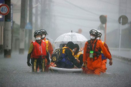 Japan, Kurume: Feuerwehrleute tragen gestrandete Anwohner auf einem Boot durch eine von starkem Regen &uuml;berflutete Stra&szlig;e in Kurume, Pr&auml;fektur Fukuoka, Westjapan. Sintflutartige Regenf&auml;lle, die den S&uuml;dwesten Japans heimsuchten, l&ouml;sten am fr&uuml;hen Freitag eine Schlammlawine aus, die einige Menschen verschluckte und zu &Uuml;berschwemmungen und weiteren Erdrutschen in der Region zu f&uuml;hren drohte.&nbsp;