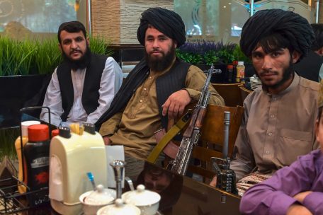 Nie ohne Waffe im Bild: Taliban-K&auml;mpfer warten in einem Kabuler Restaurant auf ihr Essen