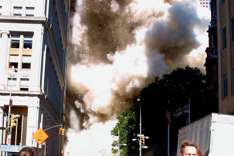 Menschen fl&uuml;chten vor der Staubwolke nach dem Zusammenbruch des ersten Turms.