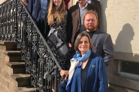 Die Besuchergruppe (von unten nach oben): Esther Nelson, Dieter Ulken, Clara Ulken, Paul Bretz, John Lanckohr, Bürgermeister Christian Miny, Gemeindesekretär Jean-Marc Clesen und Billie Schaack, Verantwortliche des Foyer Arcus, der heute im Hauptgebäude des einstigen Gehöfts untergebracht ist 