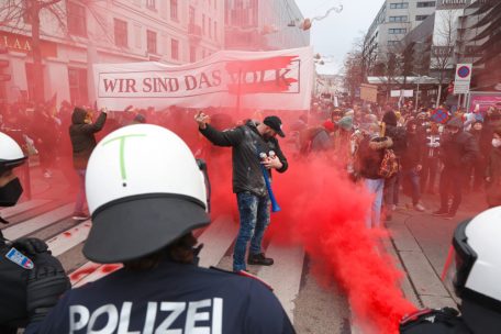 Demonstranten sind w&auml;hrend eines Protests in Wien gegen die Corona-Ma&szlig;nahmen in dem Land von der Polizei konfrontiert, w&auml;hrend roter Rauch aufsteigt