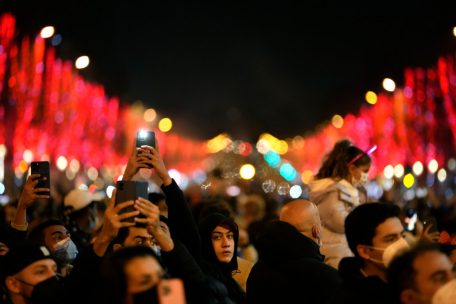 Menschen feiern die Silvesternacht auf der Avenue Champs Elysees in Paris