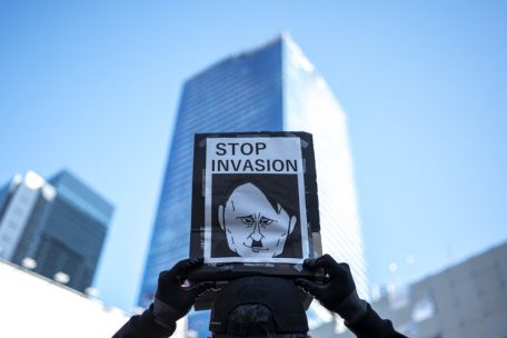 Ein Demonstrant h&auml;lt ein Plakat, w&auml;hrend sich Menschen im Tokioter Stadtteil Shibuya versammeln, um gegen den Einmarsch Russlands in die Ukraine zu protestieren