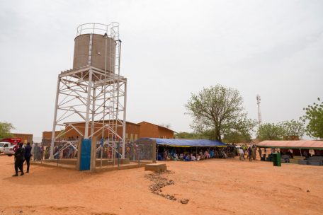 Der Dorfplatz von Simiri. Links der neu errichtete Wasserturm, rechts das aufgebaute Zelt f&uuml;r die Ehreng&auml;ste.