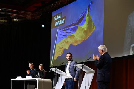 Nicolas Zharov (LUkraine) trat als Gastredner auf. Im Hintergrund die Farben der Ukraine, nicht zu verwechseln mit den neuen Farben der CSV …