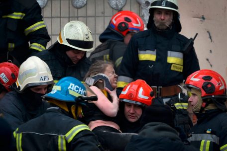 Retter tragen eine Frau aus den Tr&uuml;mmern des nach einem Raketeneinschlag zerst&ouml;rten Wohnhauses in Dnipro