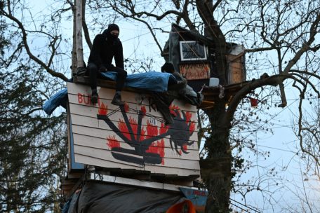 Einer der letzten verbliebenen Klimaaktivisten sitzt am 15.1. auf einem Haus auf Stelzen im sogenannten Fantasialand