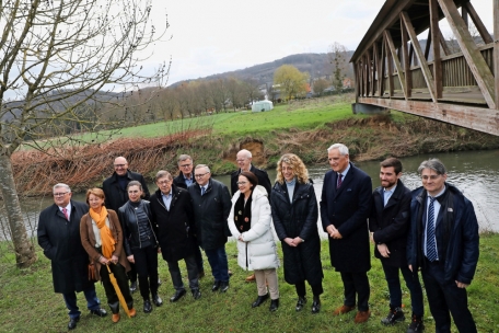 Die Projektpartner und weitere Beteiligte am Ort des Geschehens: Im Hintergrund die Holzbrücke, die bald abgebaut werden wird