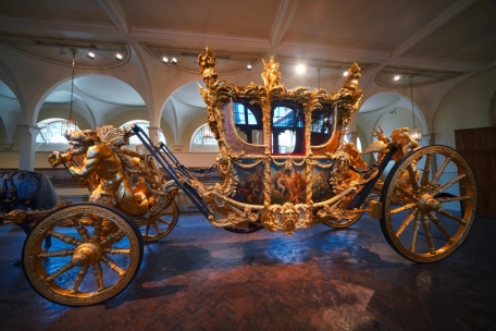 Die goldene Staatskutsche steht in den Royal Mews (Stallungen) im Buckingham Palace ausgestellt. König Charles III. und seine Königsgemahlin werden in der Diamond Jubilee State Coach, einer geschlossenen Kutsche mit sechs Pferden, am 6. Mai 2023 zu den Feierlichkeiten der Krönung fahren und diese nach der Zeremonie in der Gold State Coach, der goldenen Staatskutsche, verlassen. 