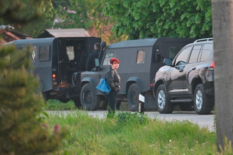 Eine Einheimische steht neben Polizeifahrzeugen in Dubona