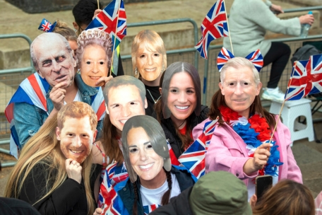 Zuschauer mit k&ouml;niglichen Masken stehen vor der Kr&ouml;nungszeremonie von K&ouml;nig Charles III. und K&ouml;nigin Camilla im Zentrum Londons