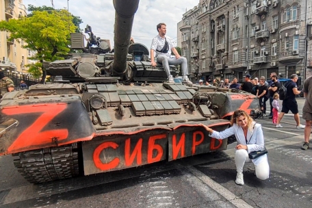 Eine Frau kniet im russischen Rostow am Don für ein Foto vor einem gepanzerten russischen Fahrzeug mit der Aufschrift „Sibirien“, das in einer Straße geparkt ist. Russlands Präsident Putin hat die Blockade wichtiger Objekte in der südrussischen Stadt Rostow am Don durch die Söldnertruppe Wagner bestätigt. „Faktisch ist die Arbeit von Organen der zivilen und militärischen Führung blockiert“, sagte Putin am Samstag in einer Ansprache ans russische Volk im Staatsfernsehen.