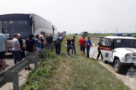 Rettungskräfte verteilen Wasser an Menschen, die wegen der Bewegung von Militärkonvois auf der gesperrten Don-Autobahn in der Region Rostow nicht fahren können