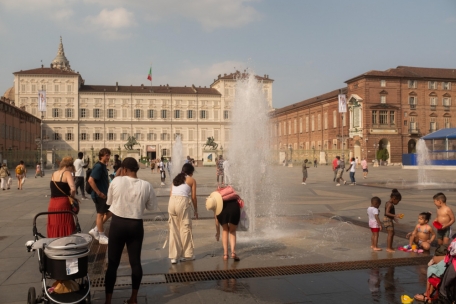 Menschen kühlen sich in dem Brunnen der Piazza Castello in Turin ab