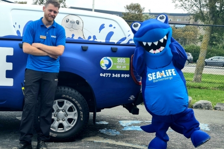 Jonathan Meul vor dem Einsatzwagen mit dem Sea-Life-Maskottchen