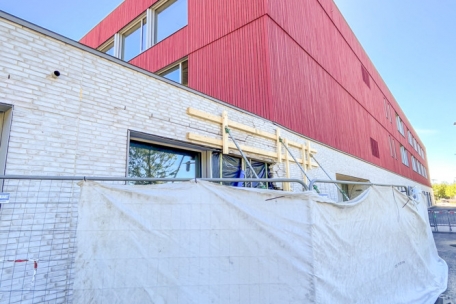 Hinter der weißen Fassade verbirgt sich der administrative Teil, hinter der roten die Klassensäle